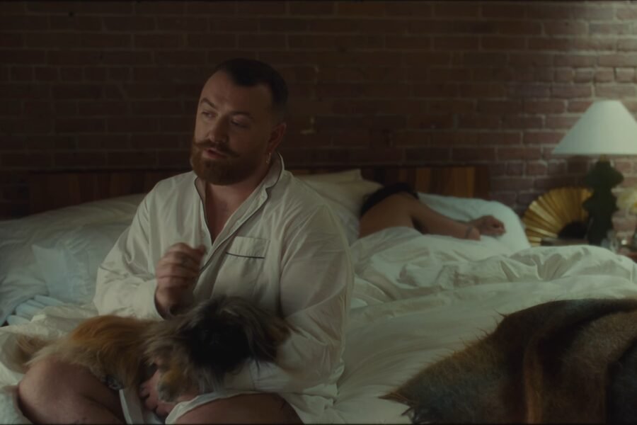 Sam Smith no clipe de My Guy, deitado numa cama com um cachorro